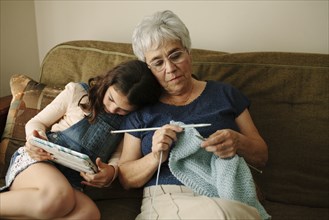 Grandmother and granddaughter relaxing in living room