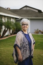 Older woman standing in backyard