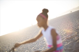 Defocused view of girl riding bicycle on beach