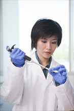 Scientist pipetting liquid into test tube in laboratory