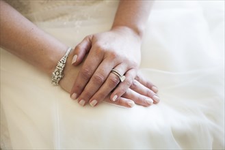 Caucasian bride wearing rings and wedding gown