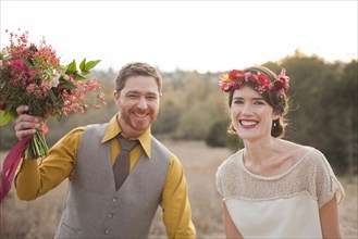 Bride and groom smiling in rural field