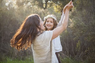 Mother and daughter dancing in park