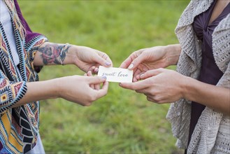 Close up of friends holding sweet love card