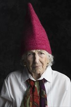 Close up of older woman wearing dunce cap