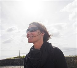 Caucasian woman wearing sunglasses and windbreaker