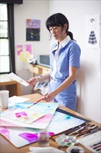 Asian designer painting in studio