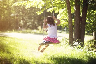 Girl playing on swing in field