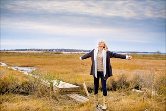 Caucasian woman standing on walkway in rural field