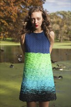 Woman wearing colorful dress near duck pond