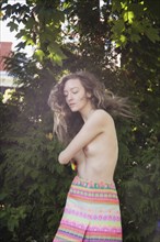 Topless woman dancing in garden