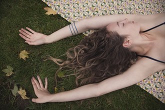 Woman laying on blanket in grass