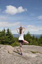 Teenage girl balancing on mountaintop