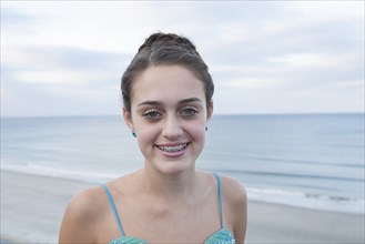 Caucasian teenage girl smiling on beach