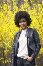 Black woman standing in park under flowering trees