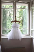 Formal dress hanging in window