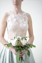 Caucasian bride in wedding dress holding bouquet