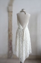 Wedding dress hanging on mannequin