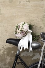 Bridal bouquet on seat of bicycle