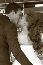 Caucasian bride and groom kissing at reception