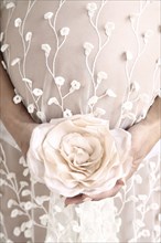 Close up of pregnant bride carrying bouquet
