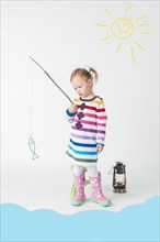 Girl playing fishing with toy fish