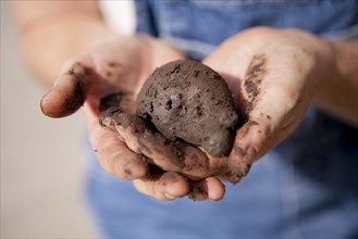 Close up of mixed race farmer holding dirt
