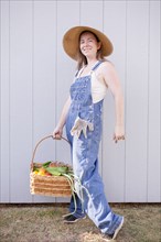 Mixed race farmer holding basket of vegetables