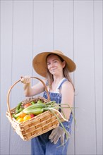 Mixed race farmer holding basket of vegetables