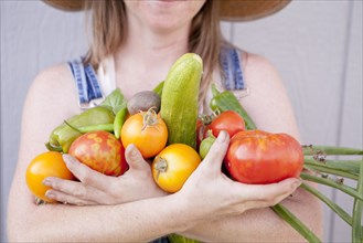 Mixed race farmer holding gathered vegetables