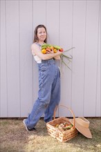 Mixed race farmer with basket of vegetables