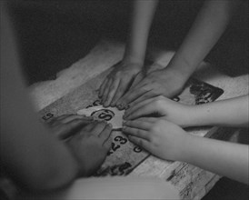 High angle view of children playing with ouija board