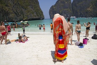 Woman in traditional headscarf standing on beach