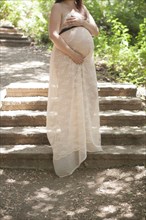 Pregnant Caucasian woman standing on hillside steps