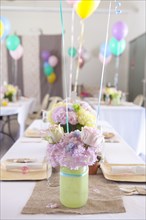 Place settings on party tables under balloons
