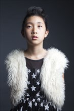 Serious Asian girl wearing furry vest