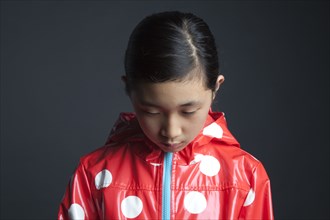 Sad Asian girl wearing raincoat