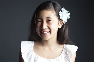 Smiling Asian girl wearing flower in her hair
