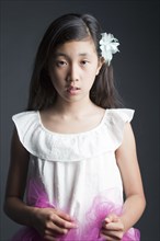 Serious Asian girl wearing flower in her hair