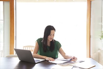 Korean woman paying bills on laptop