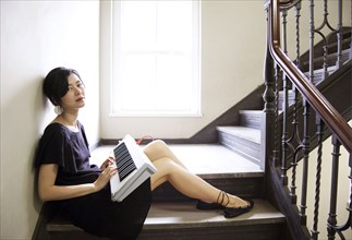 Taiwanese woman playing keyboard on staircase
