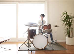 Japanese woman playing drums in living room