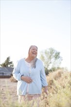 Caucasian woman laughing in backyard