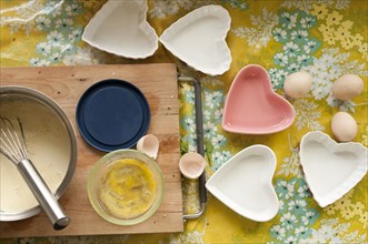 Baking tools and heart shape trays on table