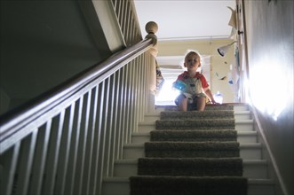 Boy playing at top of staircase