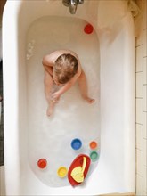 Boy playing with toys in bath