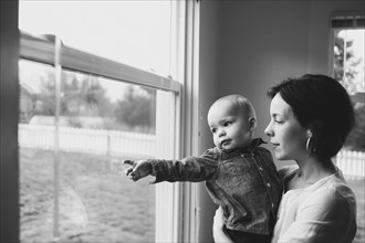 Mother and son looking out window