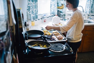 Woman cooking breakfast in kitchen