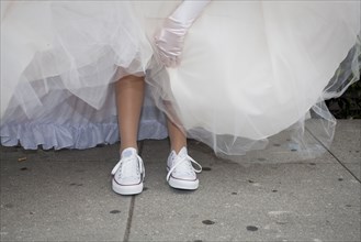 Teenage girl wearing sneakers under quinceanera dress