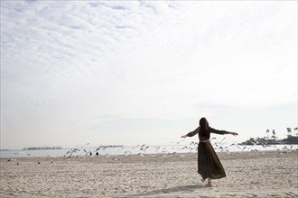 Woman in dress playing on beach